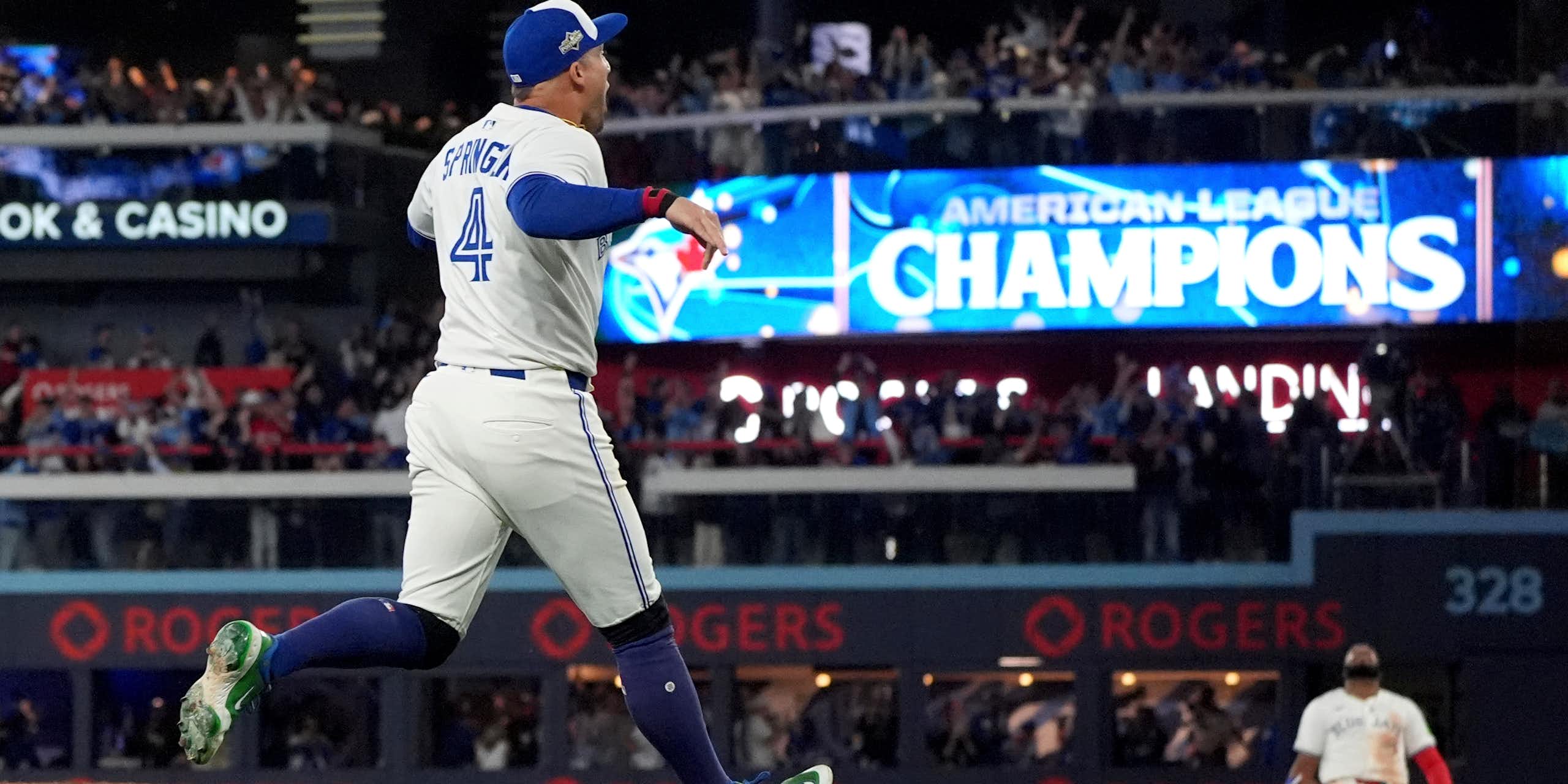 Two baseball players celebrate. One is on his knees.