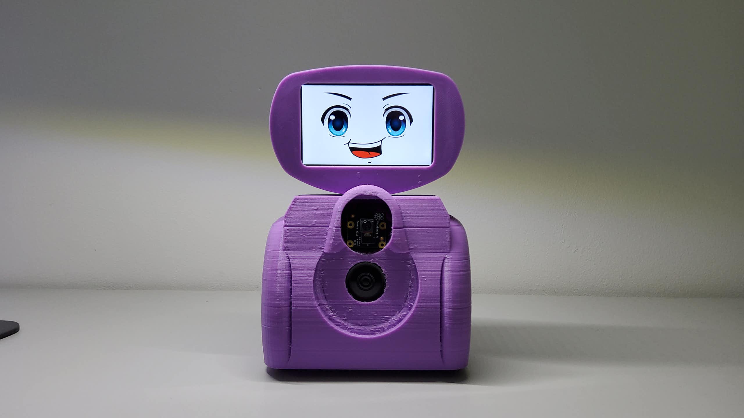 Pequeño robot de color morado con un interfaz de pantalla con ojos y boca.