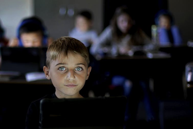 Young student working on tablet at school.