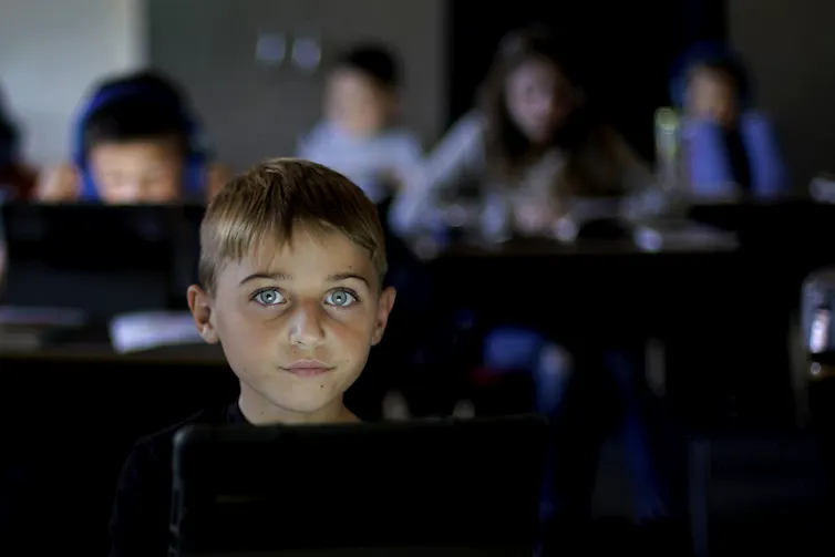 Young student working on tablet at school.