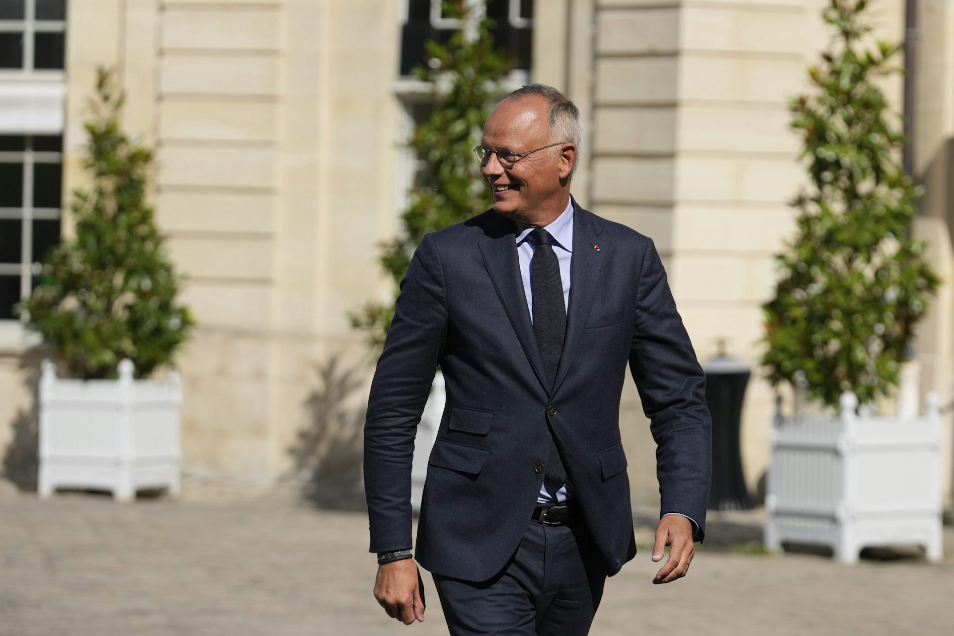 Un homme en costume marche tout sourire