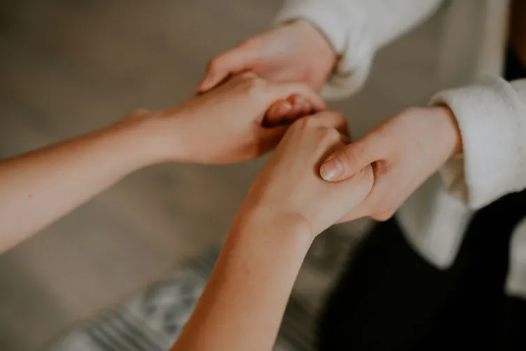 closeup of two women holding hands