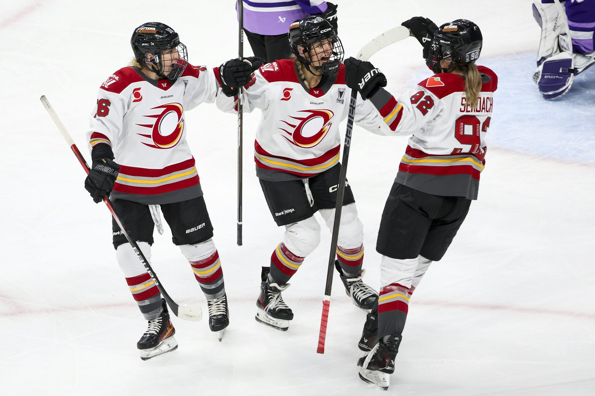 A group of women hockey players gathered on the ice rink.