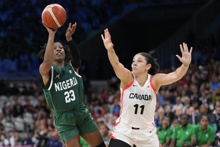 El "efecto demostración" puede inspirar a las niñas a jugar, pero sólo si las comunidades están preparadas 1 Dos jugadores de baloncesto están pescando la pelota en la cancha.