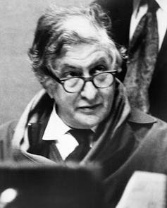 a black-and-white photo of a grey-haired man with glasses