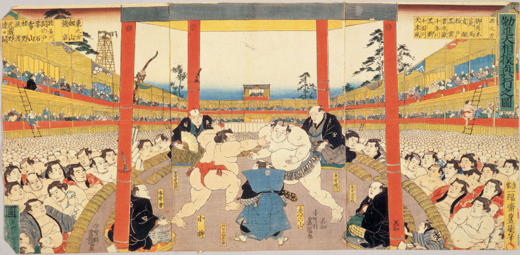 An illustration in muted colors shows two large men wrestling on a platform between red posts, as a large audience watches.