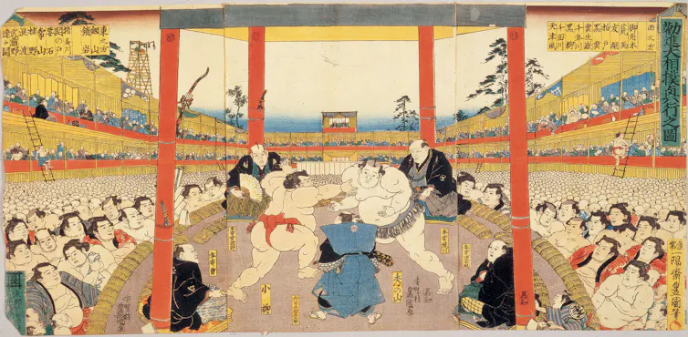 An illustration in muted colors shows two large men wrestling on a platform between red posts, as a large audience watches.