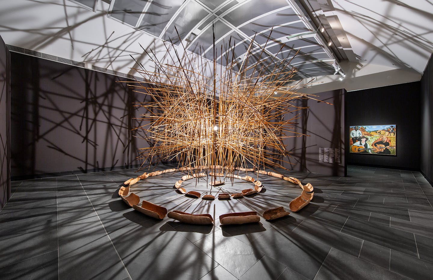 A cloud of sticks hangs in the gallery.
