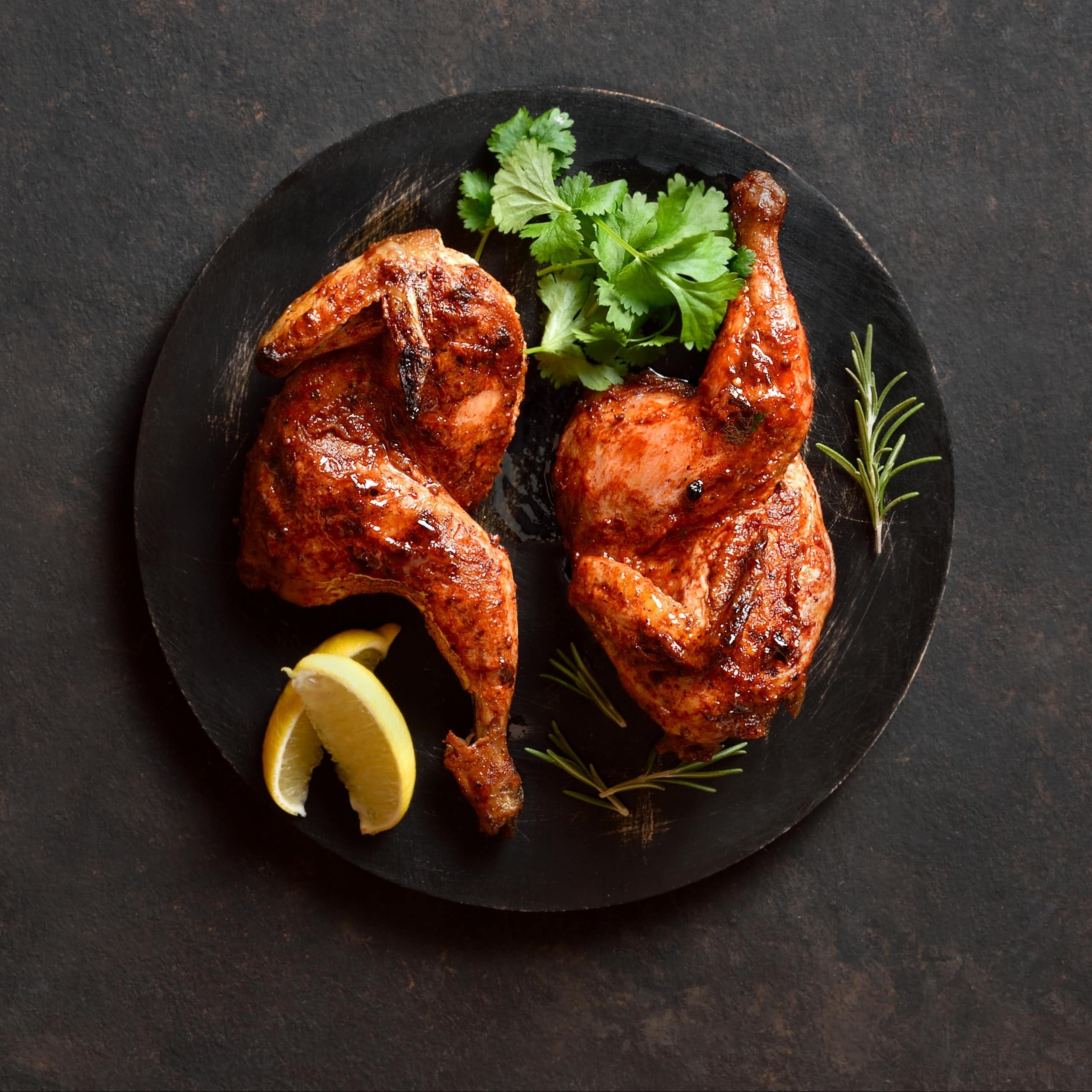 Cooked chicken on a black plate.