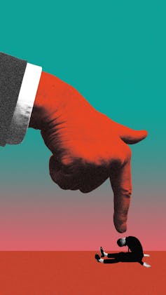 Gigantic red hand points at defeated man sitting on red floor.