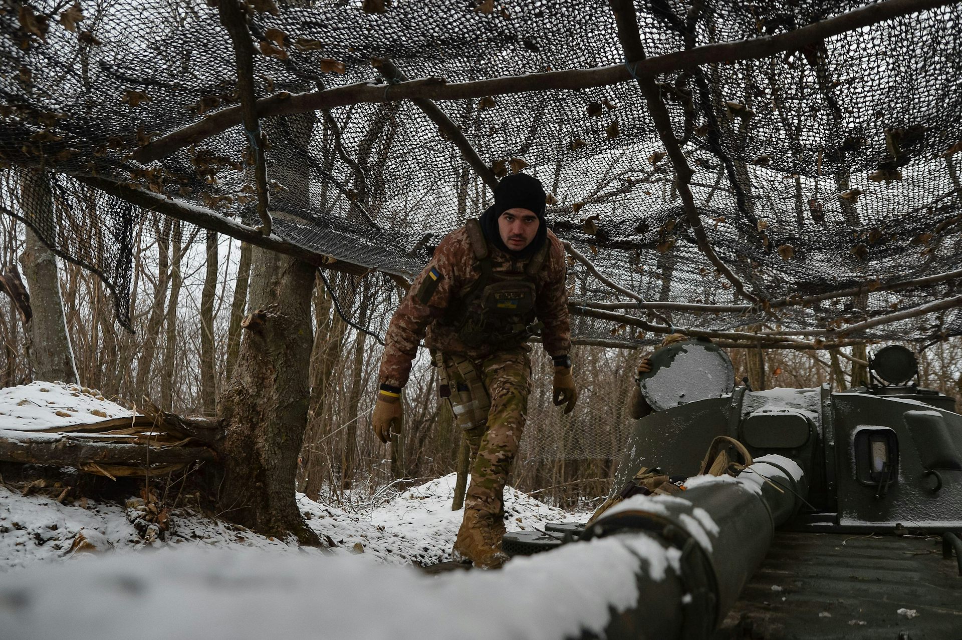 A Ukrainian serviceman at an artillery installation in the snow.