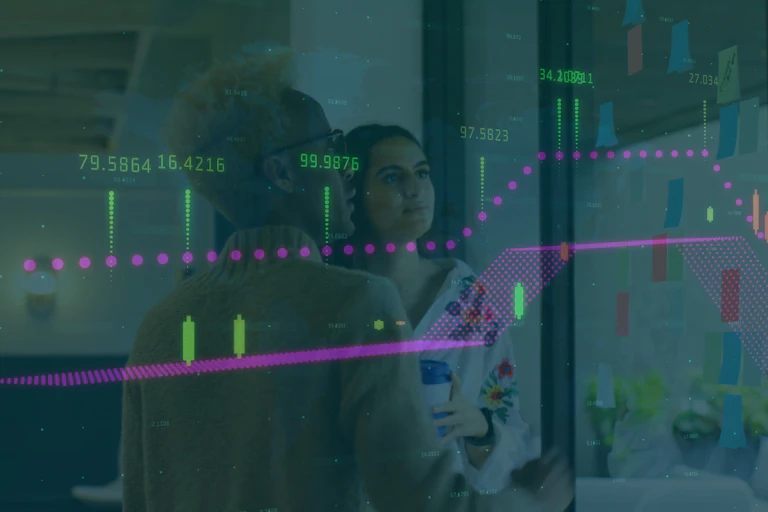 Deux femmes regardent un écran avec des graphiques financiers.