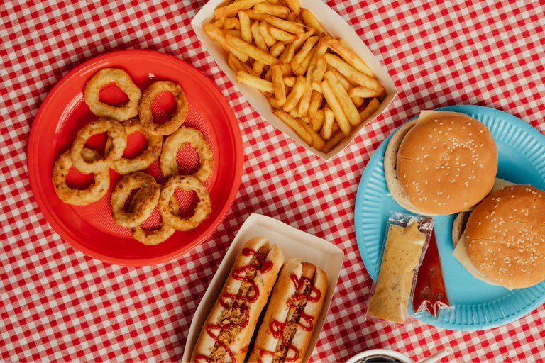 Des frites, des burgers et des hotdogs sont disposés sur une table