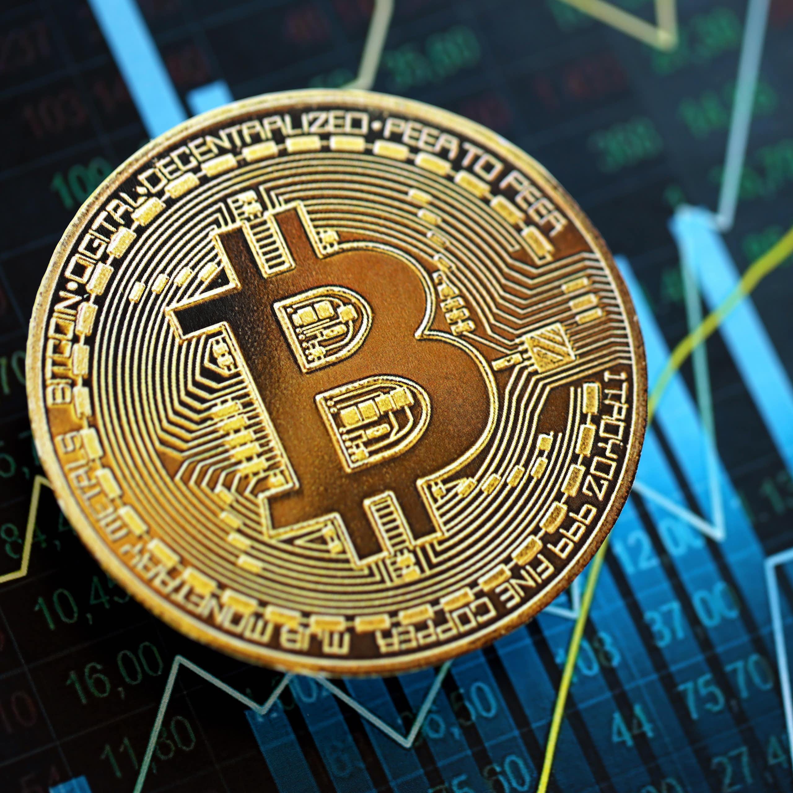 The bitcoin symbol on a background with charts