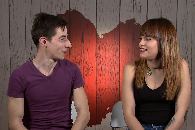 Dos jóvenes mirándose a los ojos con la imagen de un corazón al fondo.