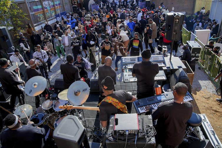 A big crowd gathers to hear musicians perform.