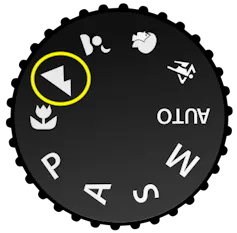 A generic camera dial featuring various modes, with the 'landscape mode' – represented by two little mountain peaks – highlighted.