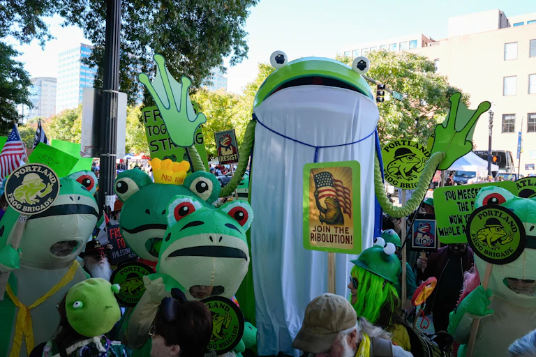 People in frog costumes gather at a 'No Kings' protest in Portland.