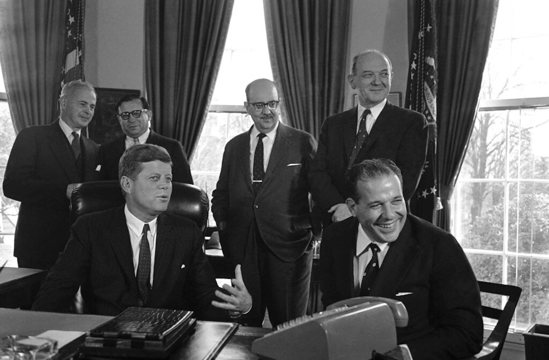 Men in suits gather at the White House.
