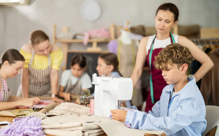 Boy using sewing machine in class