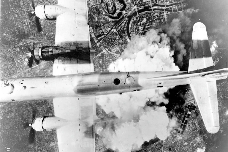 Fotografía en blanco y negro de un avión volando sobre las nubes.