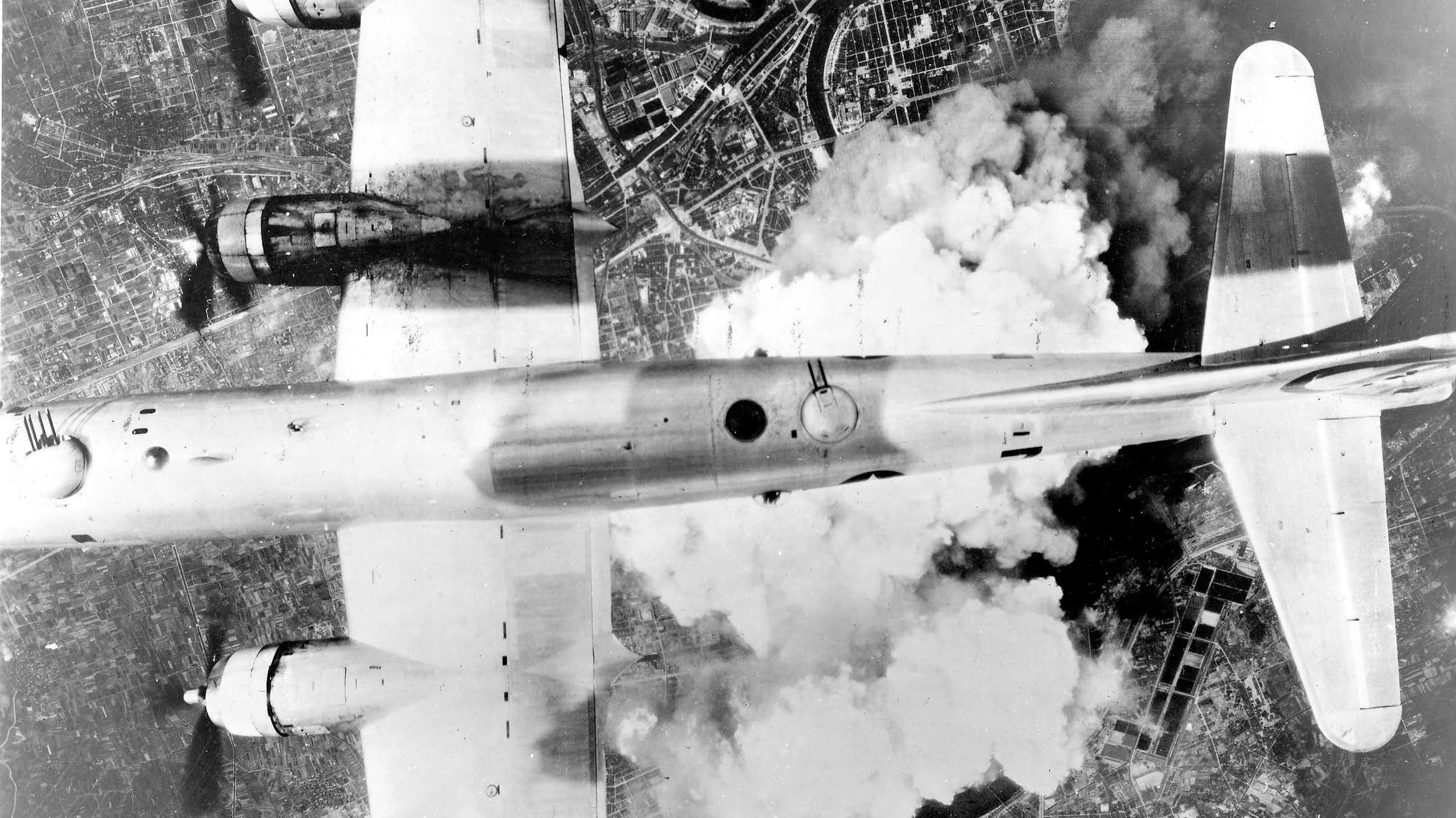 Fotografía en blanco y negro de un avión volando sobre las nubes.
