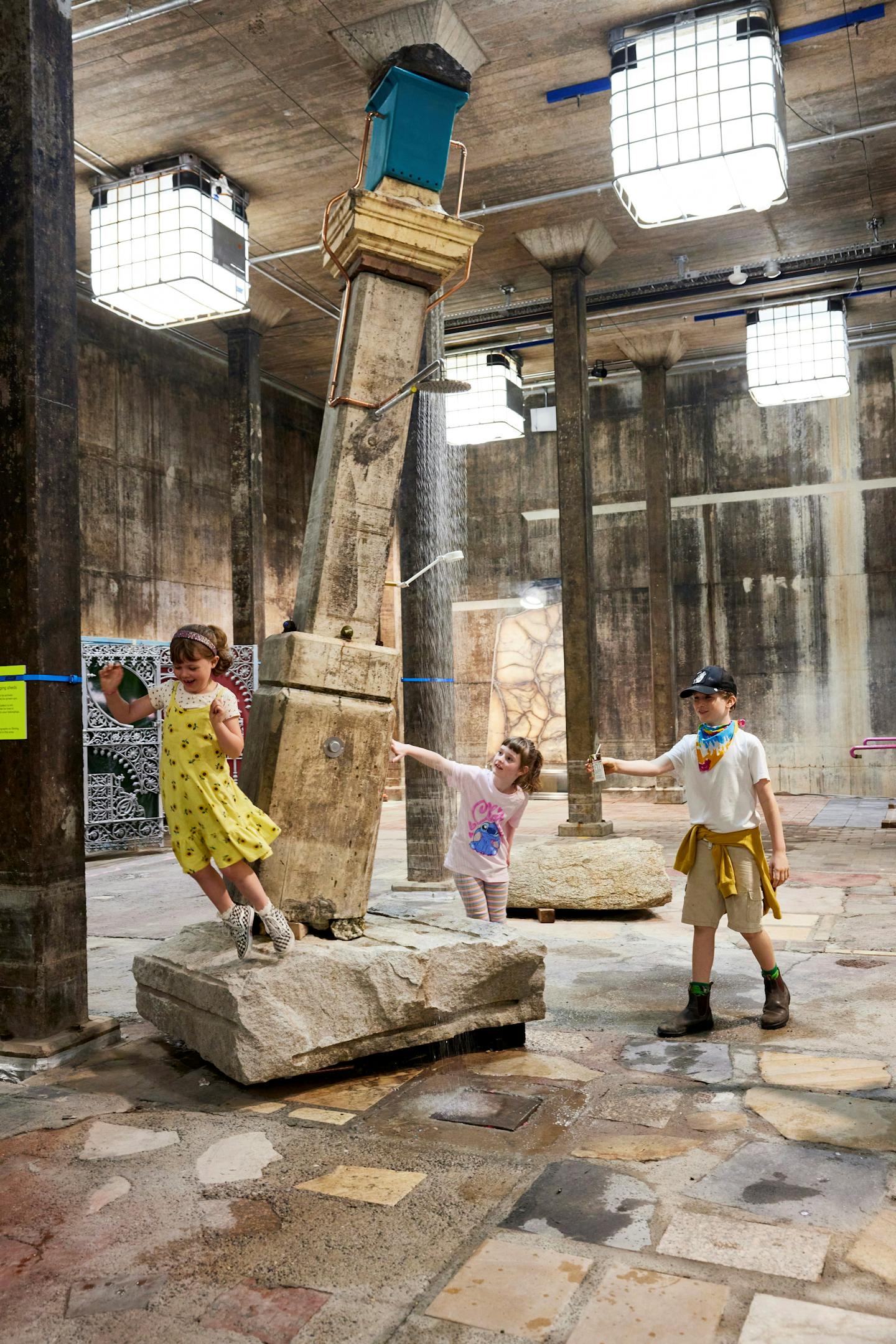 Three children play near a perilously angled plinth.