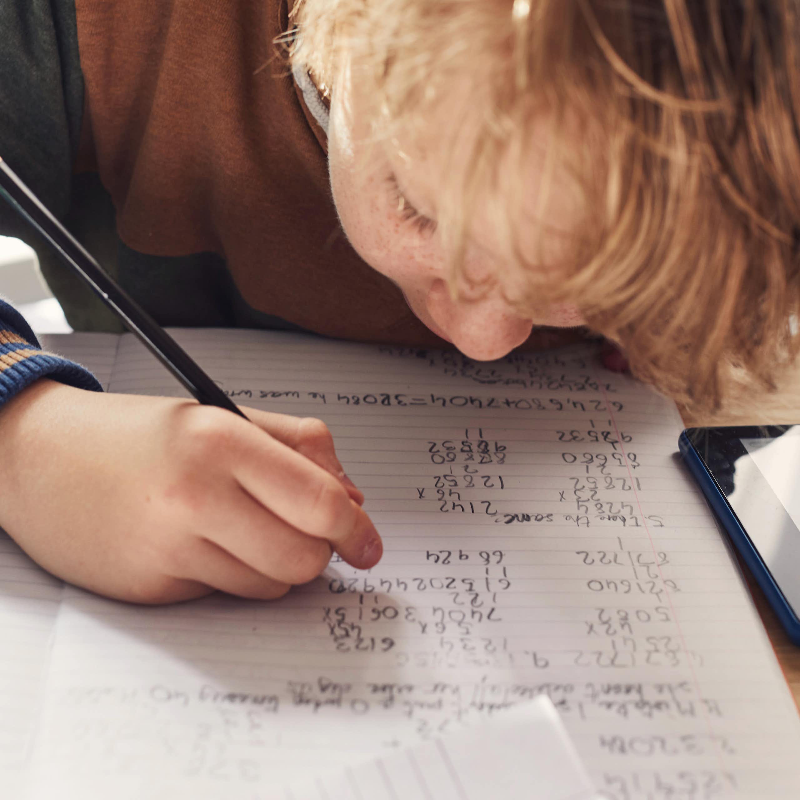 A child writing maths exercises
