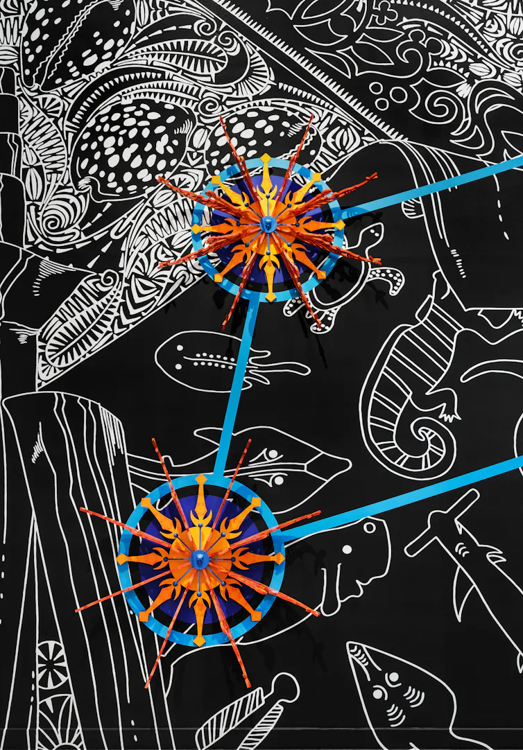 Orange wheels above white painting on black.