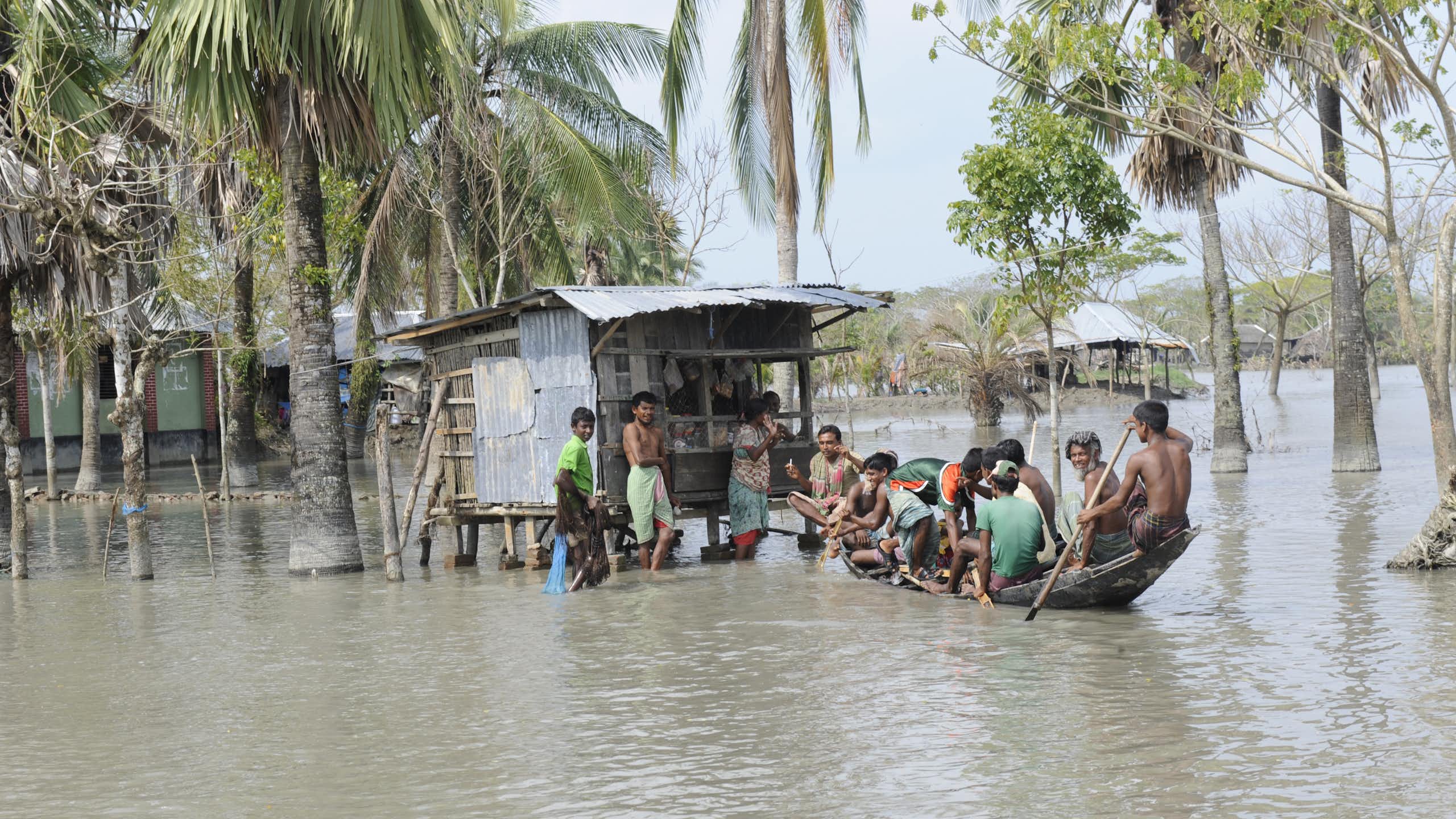 boat with people on flooded waters in Bangladesh