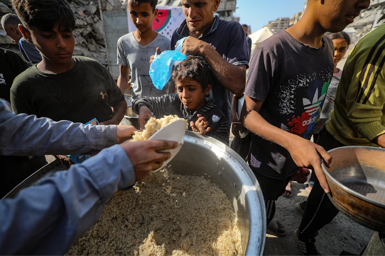 Palestinians receive food from a charity kitchen.