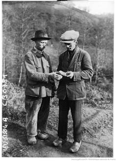 The Glozel affair: A sensational archaeological hoax made science front-page information in Nineteen Twenties France 1 two men in jackets and caps hold and examine an object outdoors