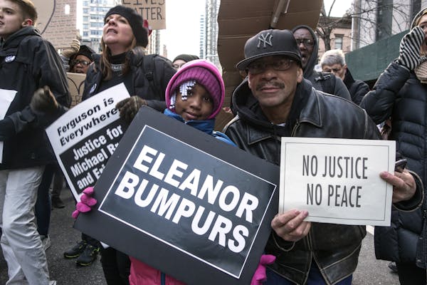 Protesters hold signs reading 'Eleanor Bumpurs,' 'No Justice No Peace,' and 'Ferguson is Everywhere Justice for Michael Brown and Eric Garner'.