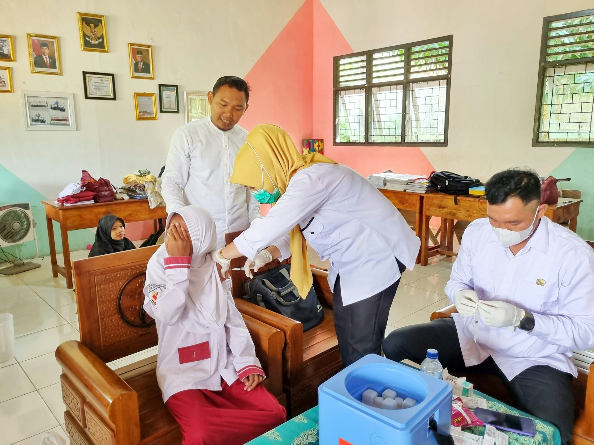 Bidan saat vaksinasi anak SD.