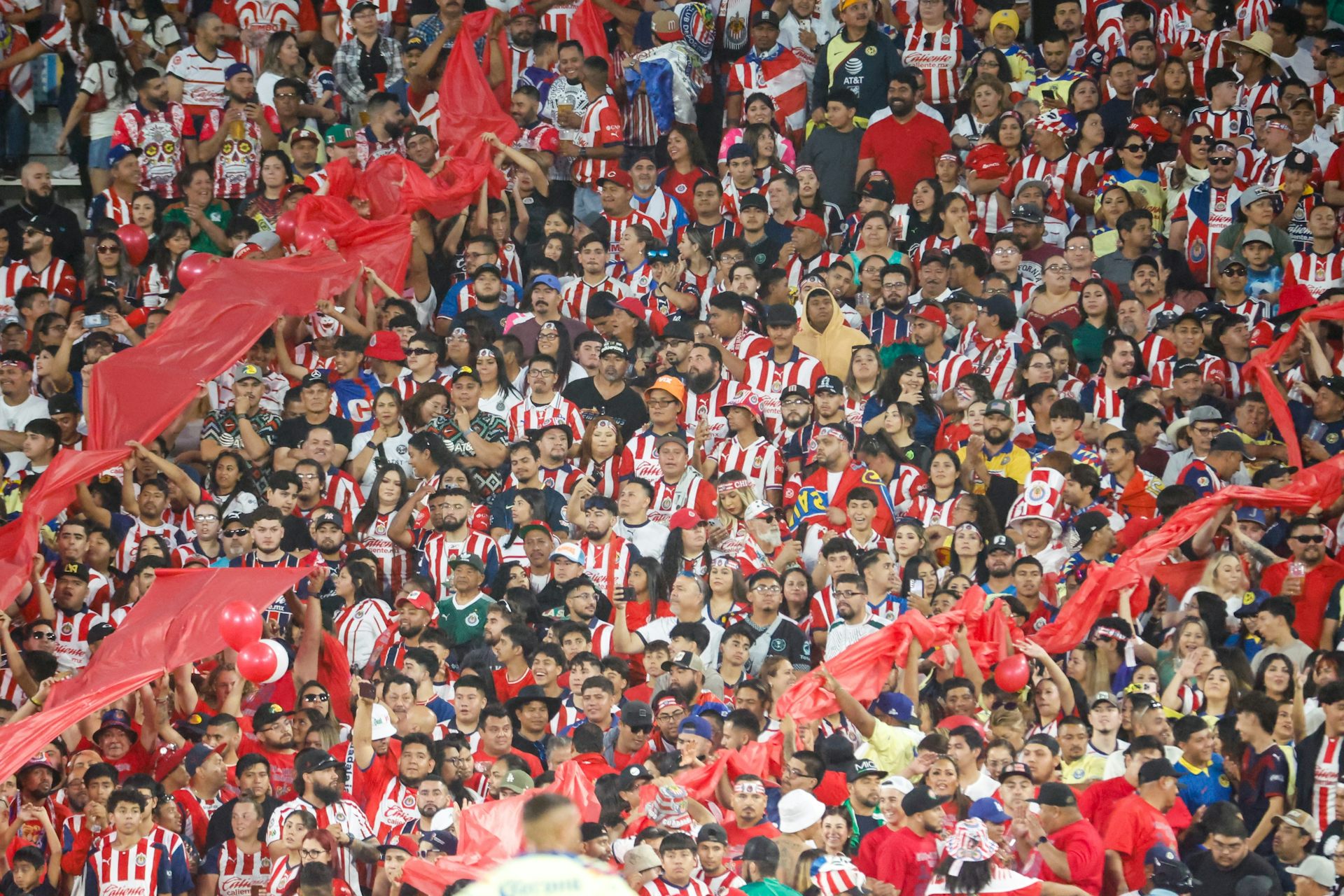 Muchos aficionados con camisetas rojiblancas en un estadio.