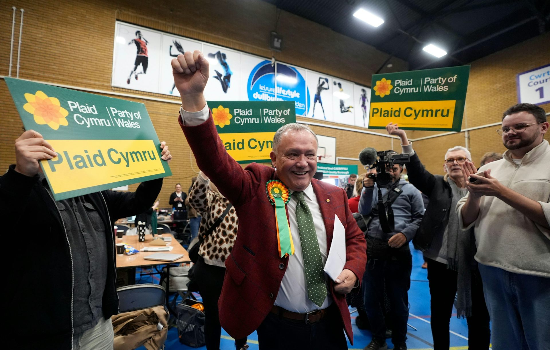 Lindsay Whittle standing at the centre with a hand in the air surrounded by his supporters