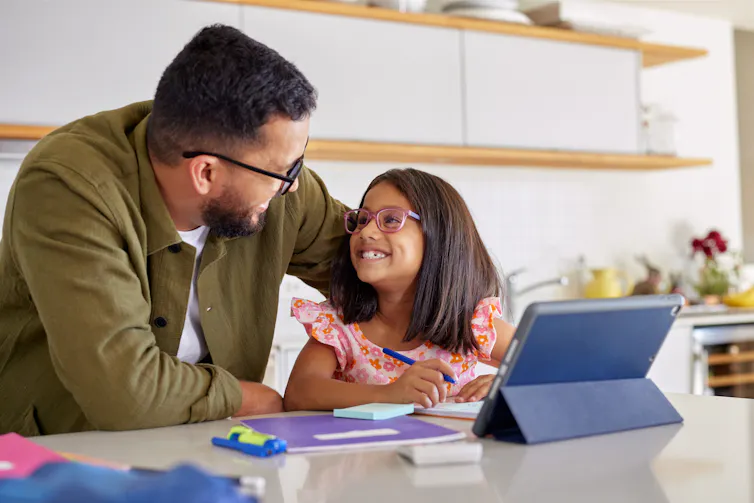 Father helping girl with homework