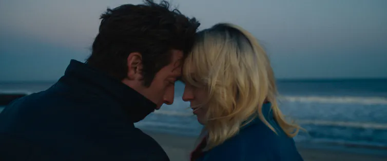 Springsteen and Faye putting their foreheads together on a beach