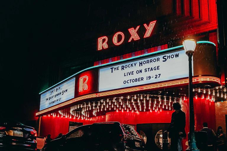 A marquee in the dark says 'The Rocky Horror Live Show'