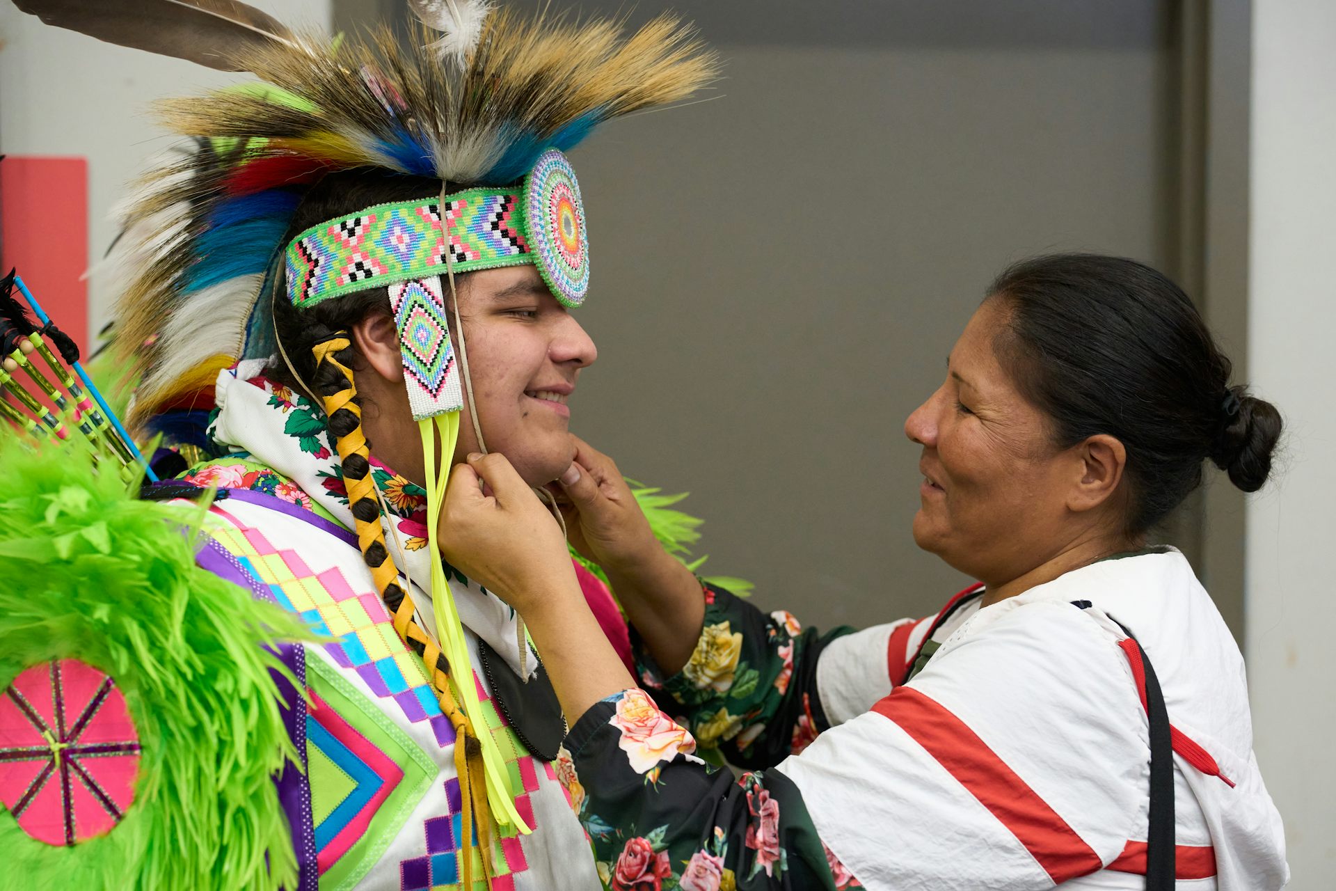 Un joven vestido con insignias se siente atraído por una mujer que lo enfrenta y se ajusta cerca de su cuello.