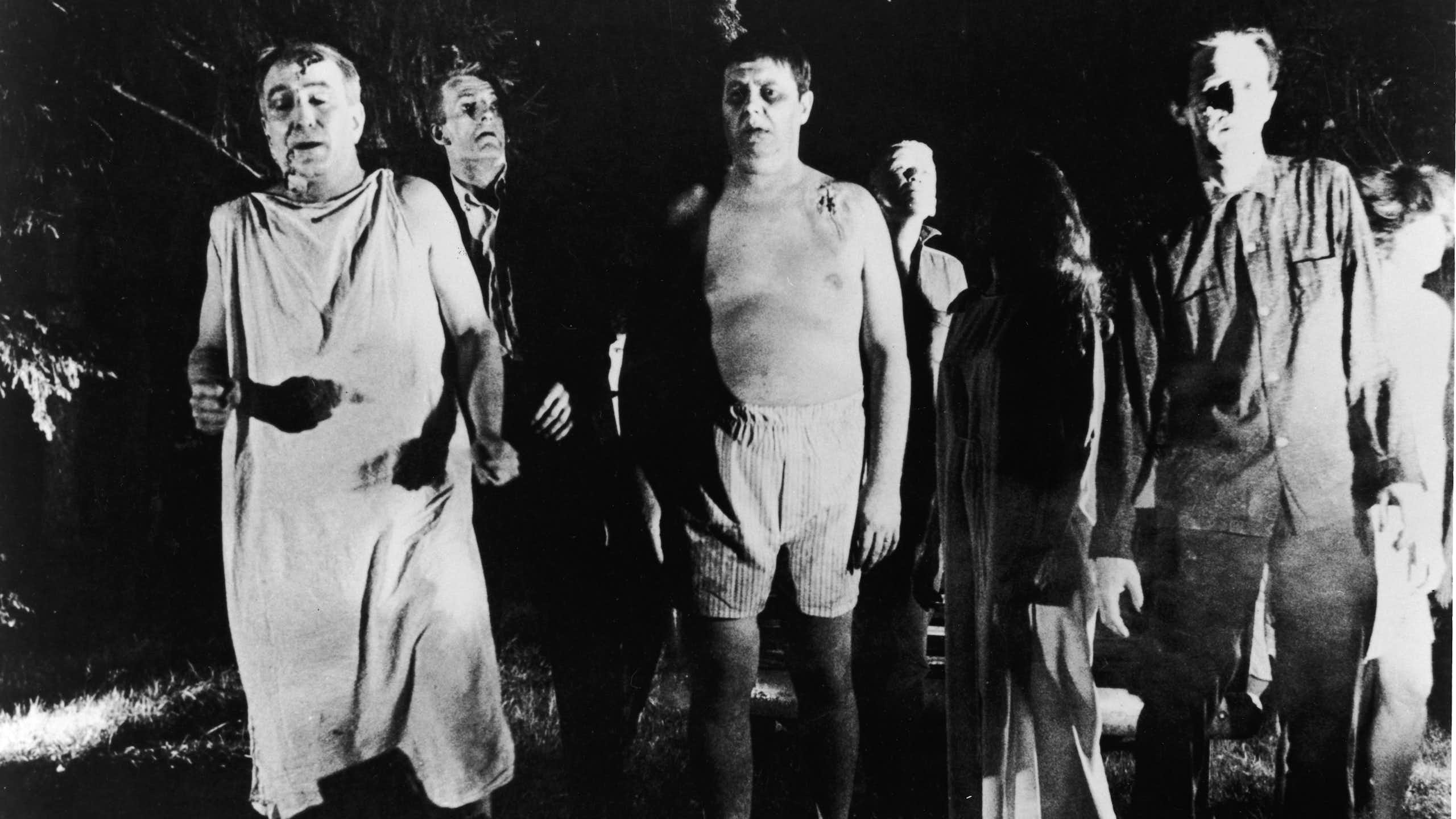 Scene from black and white film showing group of zombie-like characters