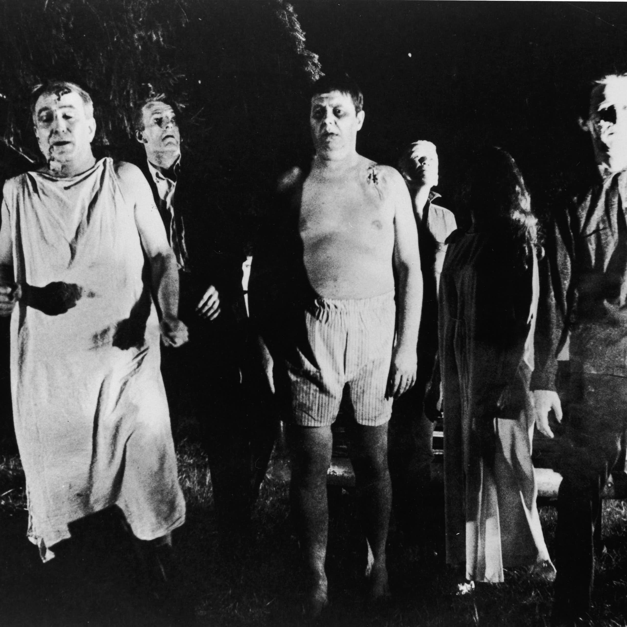 Scene from black and white film showing group of zombie-like characters