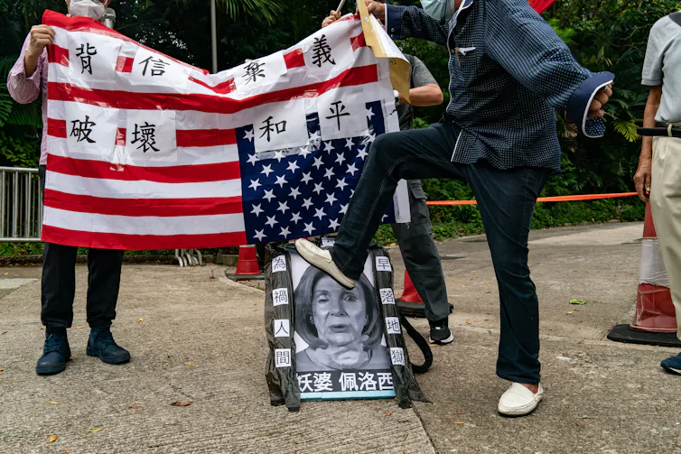 A person steps on an image of a woman's face.