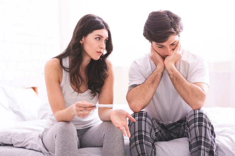 Une femme et un homme sont déçus par le résultat d’un test de grossesse.