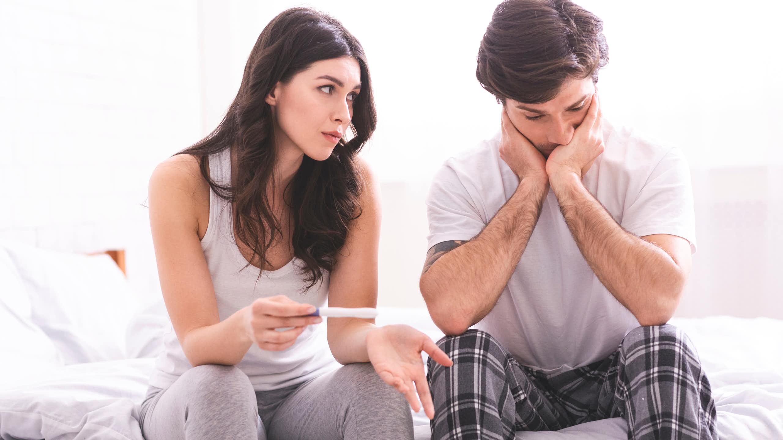 Une femme et un homme sont déçus par le résultat d’un test de grossesse.