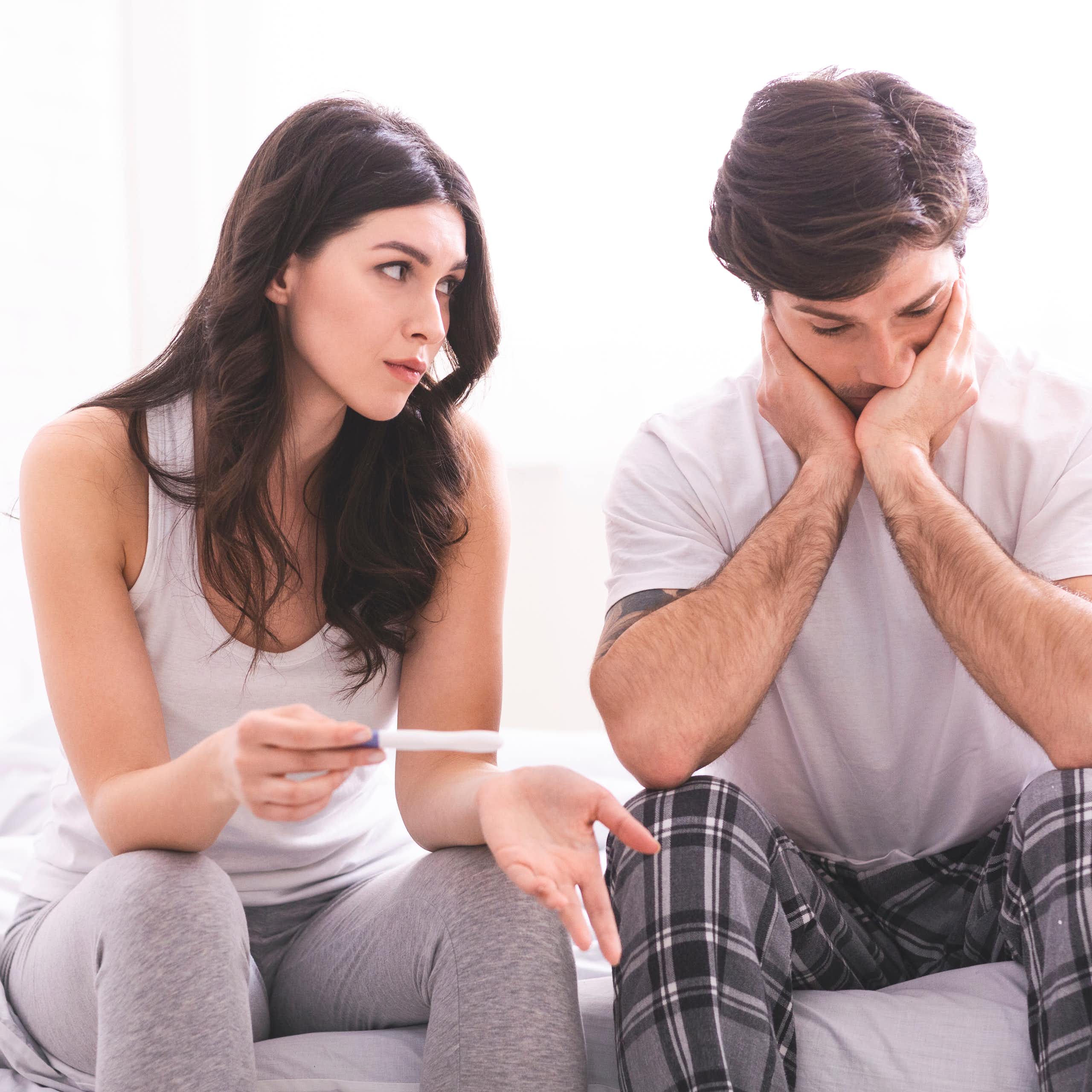 Une femme et un homme sont déçus par le résultat d’un test de grossesse.