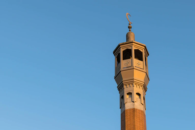 A mosque minaret against a blue sky