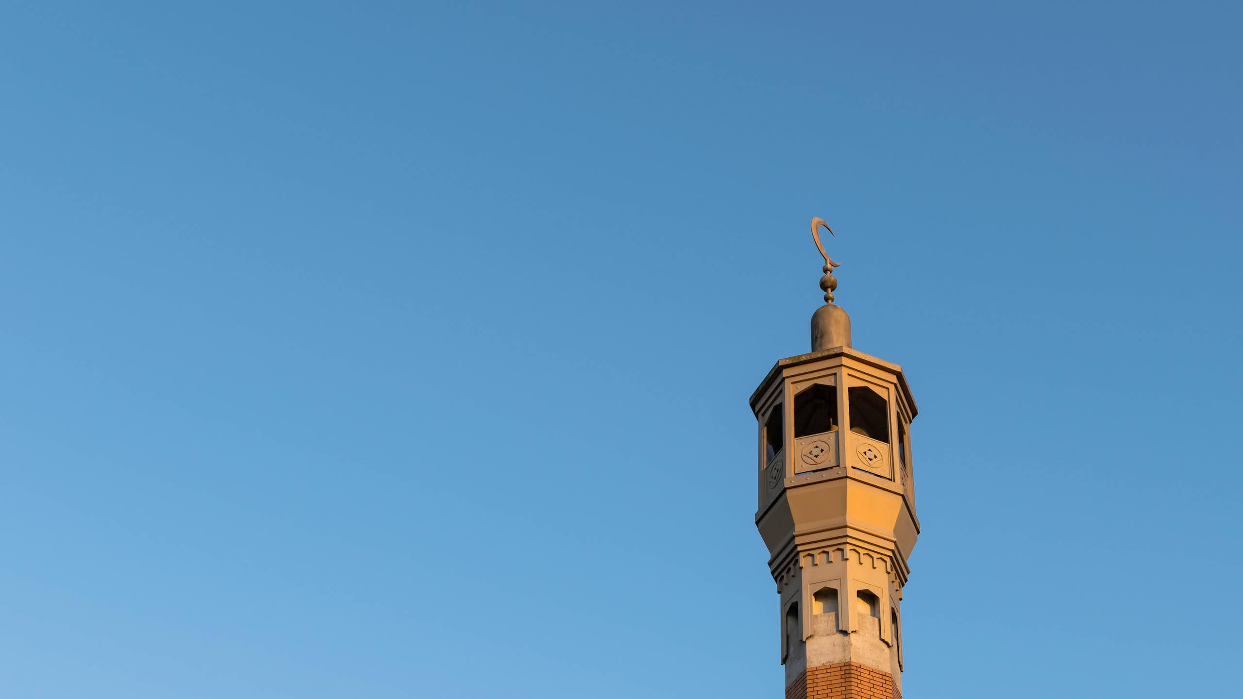 A mosque minaret against a blue sky