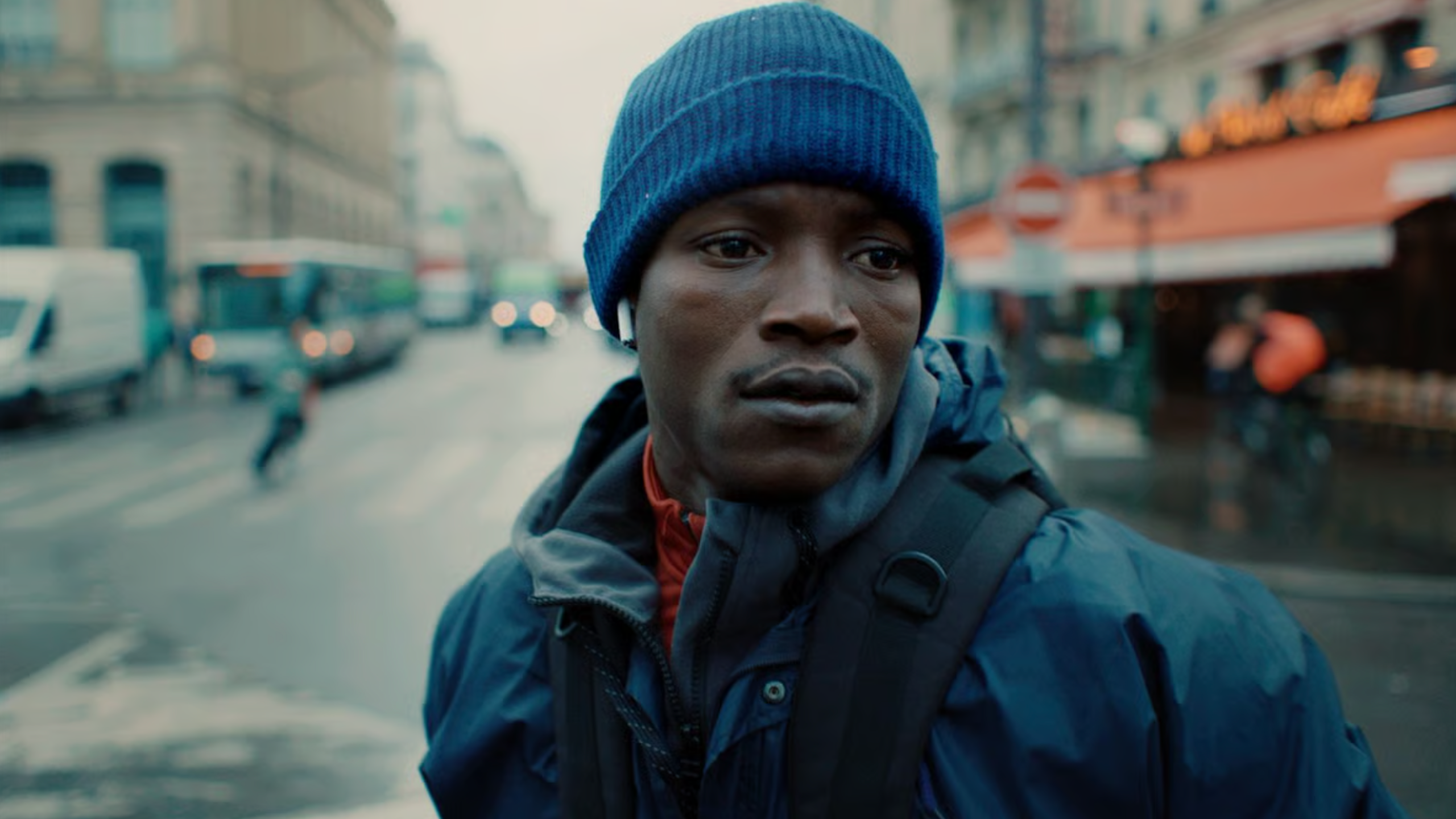 A young black man in a blue beanie looking sad.