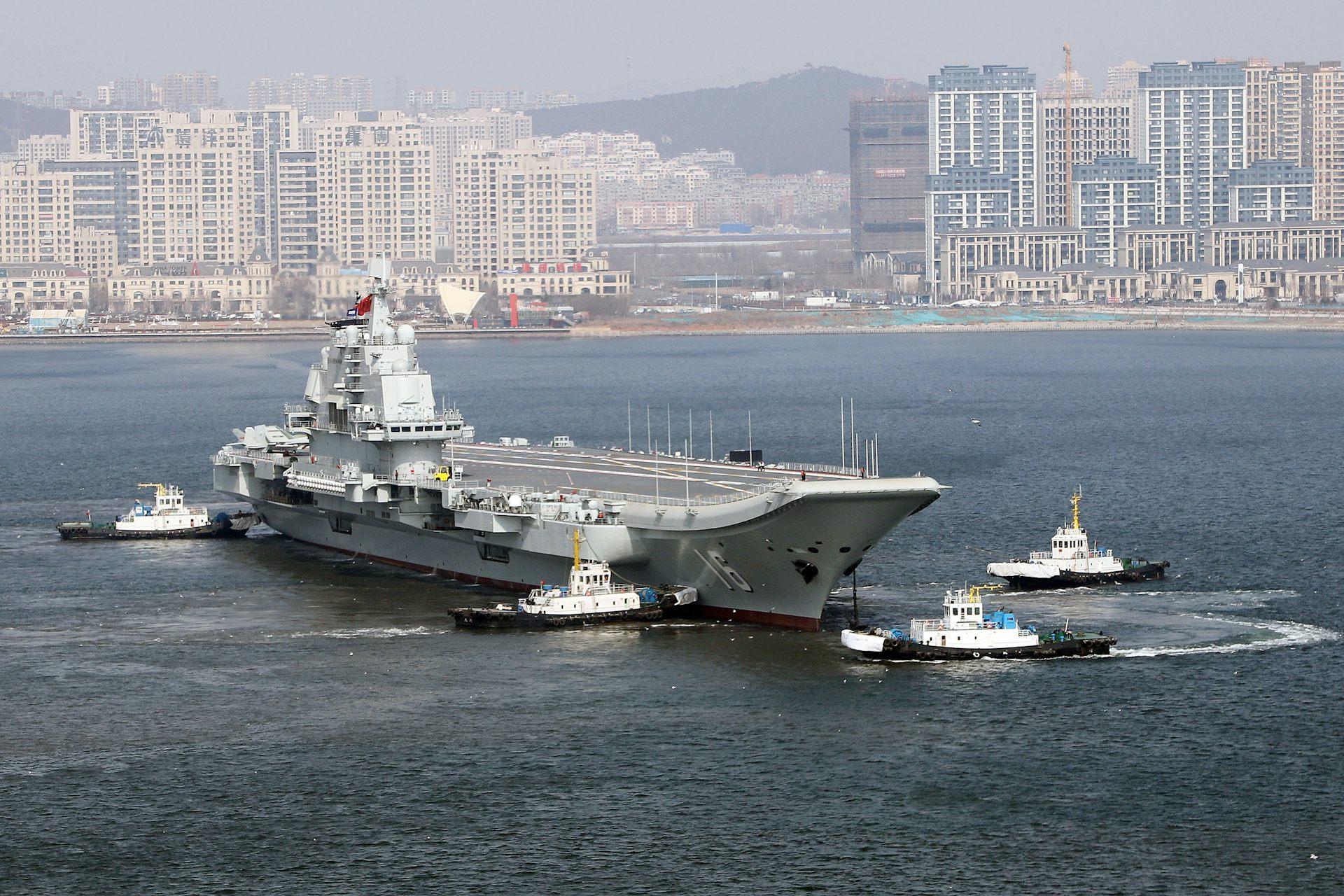 A large ship is seen in front of a city landscape.